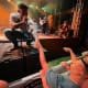 A crouching singer on a stage reaches out to an individual with cerebral palsy who is sitting in the front row of a concert.