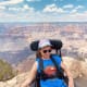 A young woman with CP smiles from her wheelchair while overlooking a view of the Grand Canyon and the vast blue sky.