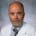 Dr. Jeff Leonard, bald with a salt and pepper close cropped beard in a lab coat.