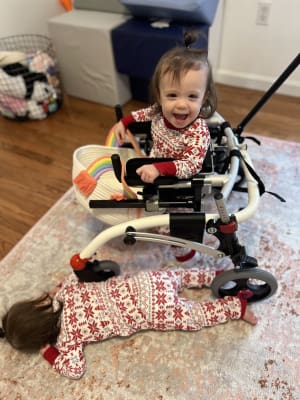 Toddler twins in red and white pajamas with one playing roadkill