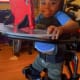 A child with cerebral palsy smiles in his standing frame.